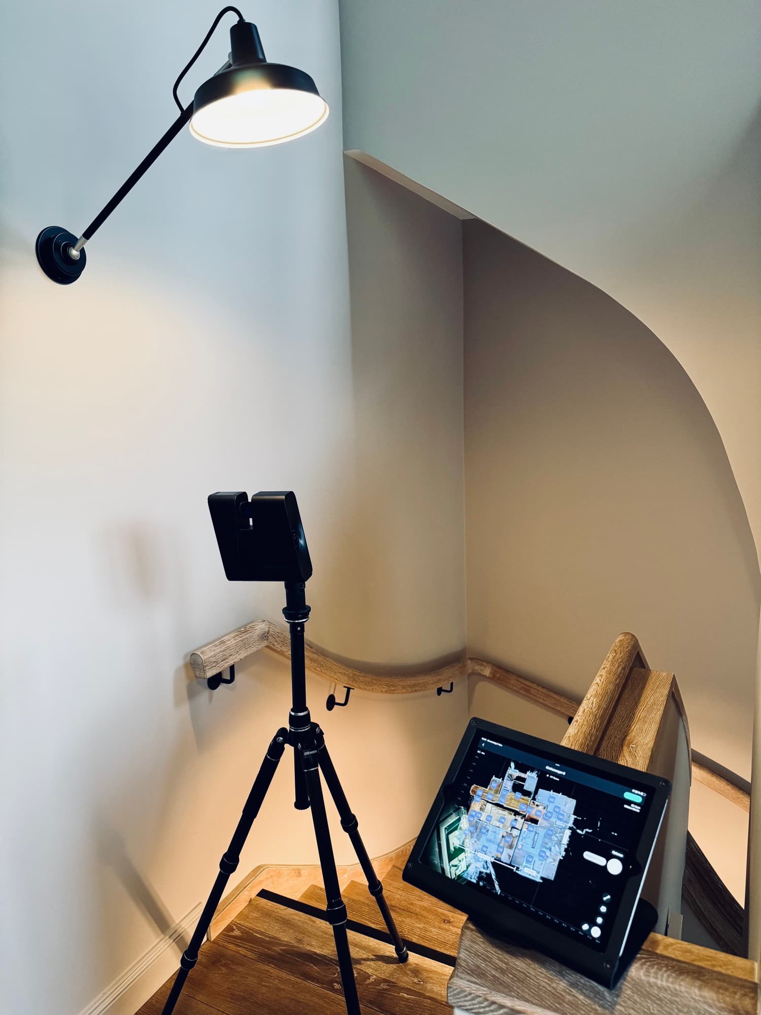 Matterport Pro3 auf dem Stativ im Treppenhaus, daneben ein Tablet mit dem entstehenden 3D-Scan